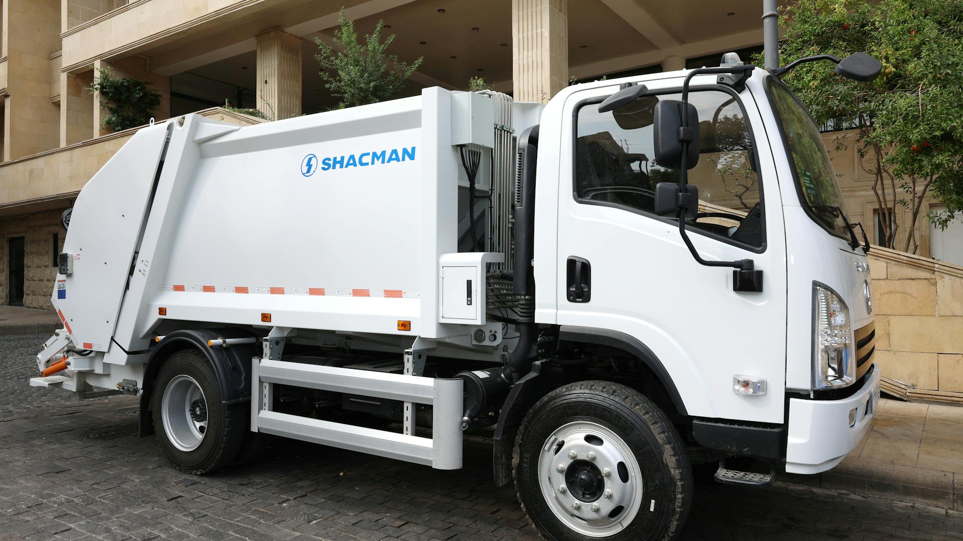 Garbage truck collecting waste on street